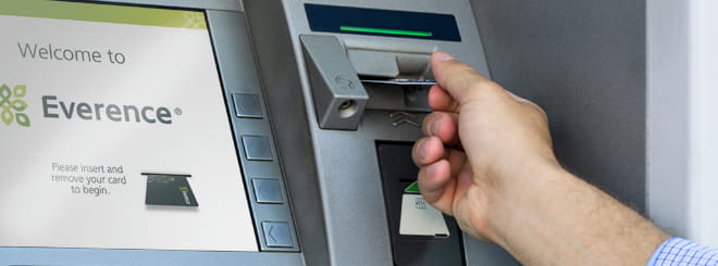 Hand inserting a card into an ATM